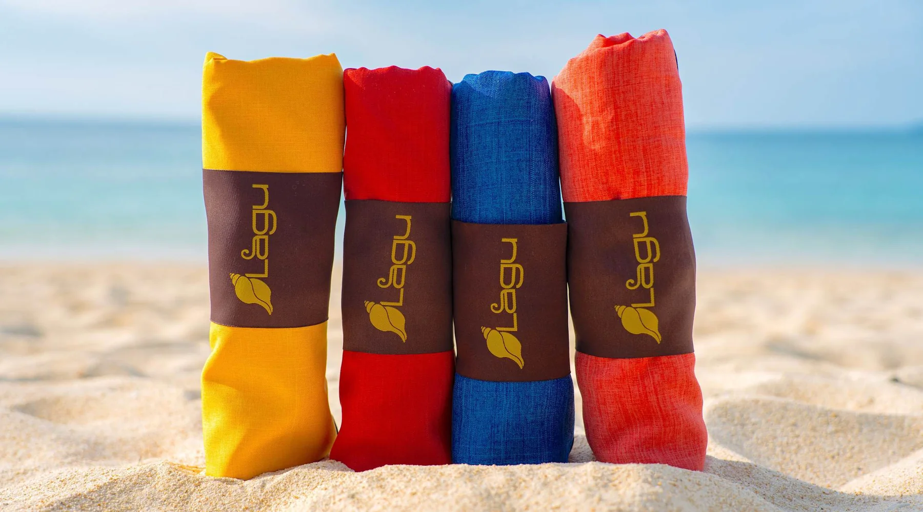 Yellow, red, blue, and orange Lagu blankets on the beach